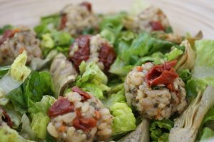 Toskana Reisbällchen mit Artischockenherzen auf Blattsalat