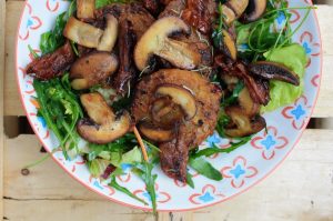 Röstis mit gebratenen Pilzen, getrockneten Tomaten auf Rucola 